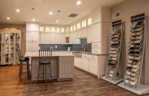 A kitchen remodeling showroom with a beautiful model of a modern kitchen and samples being displayed.