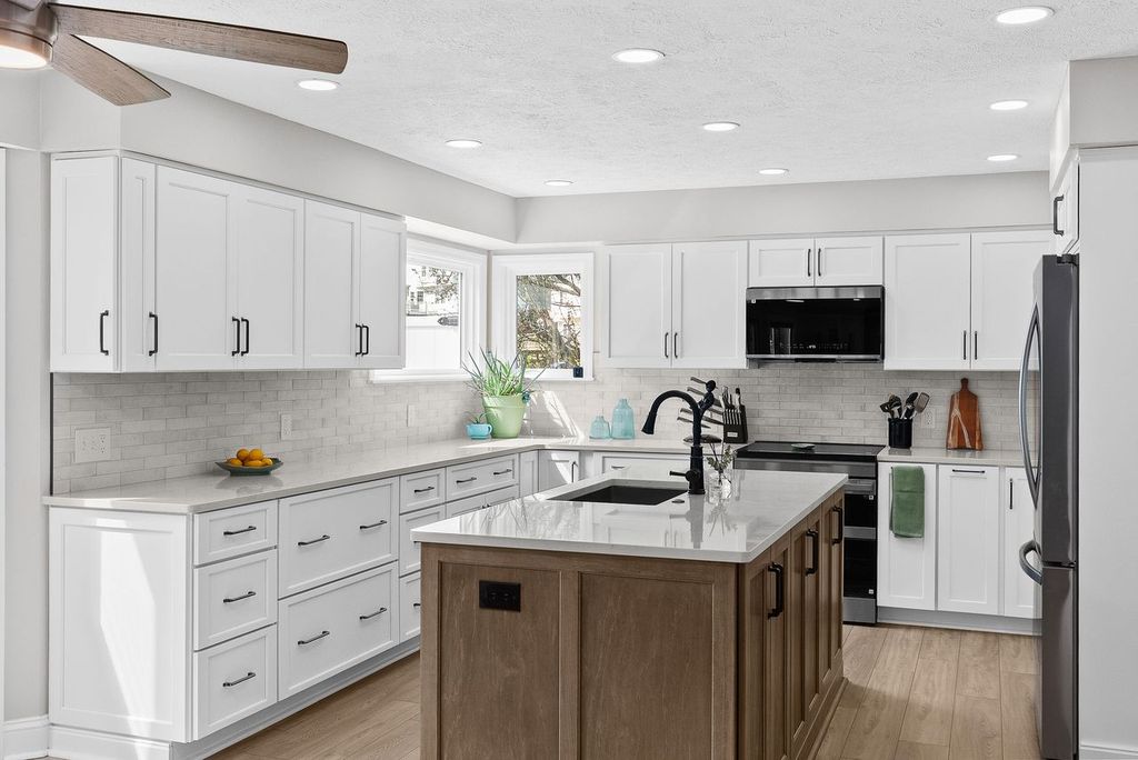 Transitional Style Gibsonia Kitchen with White Shaker-Style Cabinets Contrasted with a Modern Dark Wood Island Blending Classic and Contemporary Elements to Create a Timeless Look