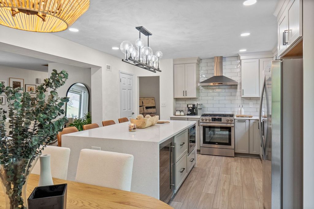 This Pittsburgh kitchen boasts a streamlined, modern design with white cabinets and stainless steel appliances.