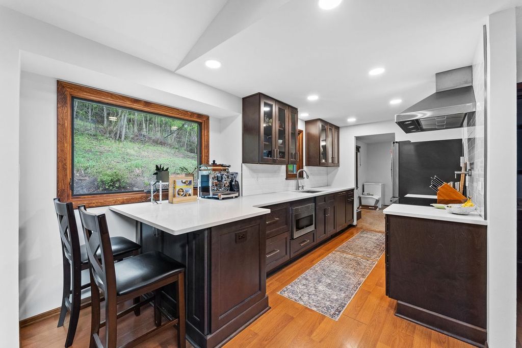 This Classic Wexford Modern Kitchen with Dark Wood Cabinets and Rich Espresso Finishes Combine Natural Elements Like Wood and Light to Create a Touch of Warmth.