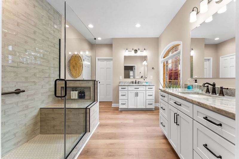 This Stunning Upper St. Clair Master Bathroom Includes a Large Walk-In Shower with Glass Enclosure, Built-In Bench and Custom Tile Surround Combining Luxury and Functionality with its Spacious Layout and High-End Finishes.