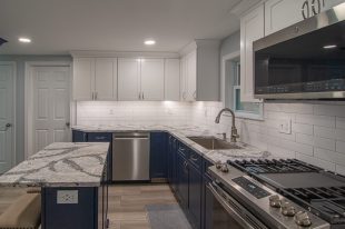 A Beautiful Kitchen using a two-tone color scheme for the painted cabinets. Warm tone on the floor helps neutralize the cold tone used in the counter tops.