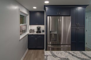 A Beautiful Kitchen using a two-tone color scheme for the painted cabinets. Warm tone on the floor helps neutralize the cold tone used in the counter tops.