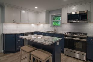 A Beautiful Kitchen using a two-tone color scheme for the painted cabinets. Warm tone on the floor helps neutralize the cold tone used in the counter tops.