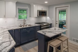 A Beautiful Kitchen using a two-tone color scheme for the painted cabinets. Warm tone on the floor helps neutralize the cold tone used in the counter tops.