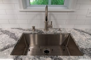 A Beautiful Kitchen using a two-tone color scheme for the painted cabinets. Warm tone on the floor helps neutralize the cold tone used in the counter tops.