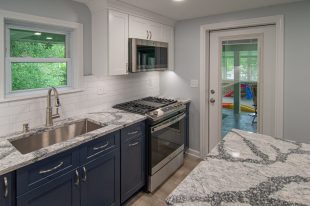 A Beautiful Kitchen using a two-tone color scheme for the painted cabinets. Warm tone on the floor helps neutralize the cold tone used in the counter tops.