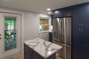 A Beautiful Kitchen using a two-tone color scheme for the painted cabinets. Warm tone on the floor helps neutralize the cold tone used in the counter tops.