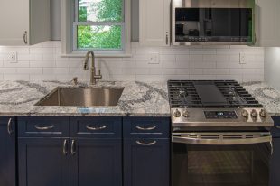A Beautiful Kitchen using a two-tone color scheme for the painted cabinets. Warm tone on the floor helps neutralize the cold tone used in the counter tops.