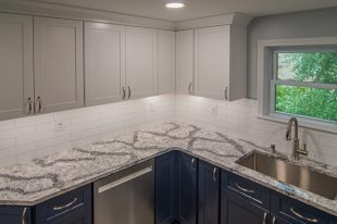 A Beautiful Kitchen using a two-tone color scheme for the painted cabinets. Warm tone on the floor helps neutralize the cold tone used in the counter tops.