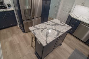 A Beautiful Kitchen using a two-tone color scheme for the painted cabinets. Warm tone on the floor helps neutralize the cold tone used in the counter tops.