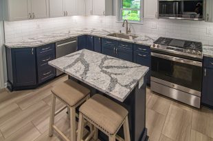 A Beautiful Kitchen using a two-tone color scheme for the painted cabinets. Warm tone on the floor helps neutralize the cold tone used in the counter tops.