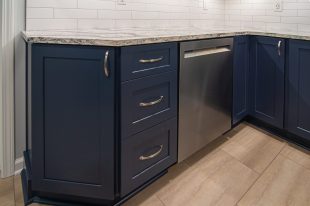 A Beautiful Kitchen using a two-tone color scheme for the painted cabinets. Warm tone on the floor helps neutralize the cold tone used in the counter tops.